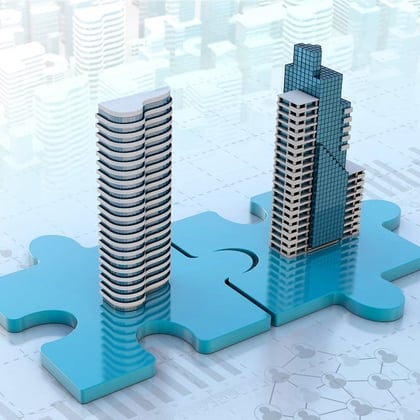 Two buildings on puzzle pieces representing mergers & acquisitions or M&A