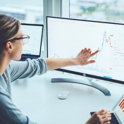 businesswoman at desk looking at charts